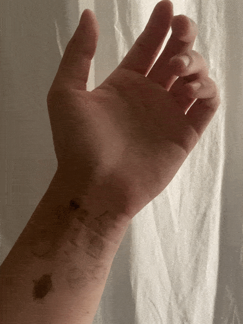 GIF of a hand hovering in space, with symbols drawn on the wrist.